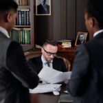 Business professionals discussing important legal documents in an office setting.